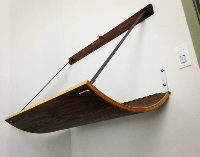 A drop-down baby-changing station I built for the bathroom of my friend's vegan restaurant, The Loaded Bowl. Baltic birch laminated, curved table with walnut veneer. Paracord lacing, steel hinge rod, and seatbelt strapping. (2016)